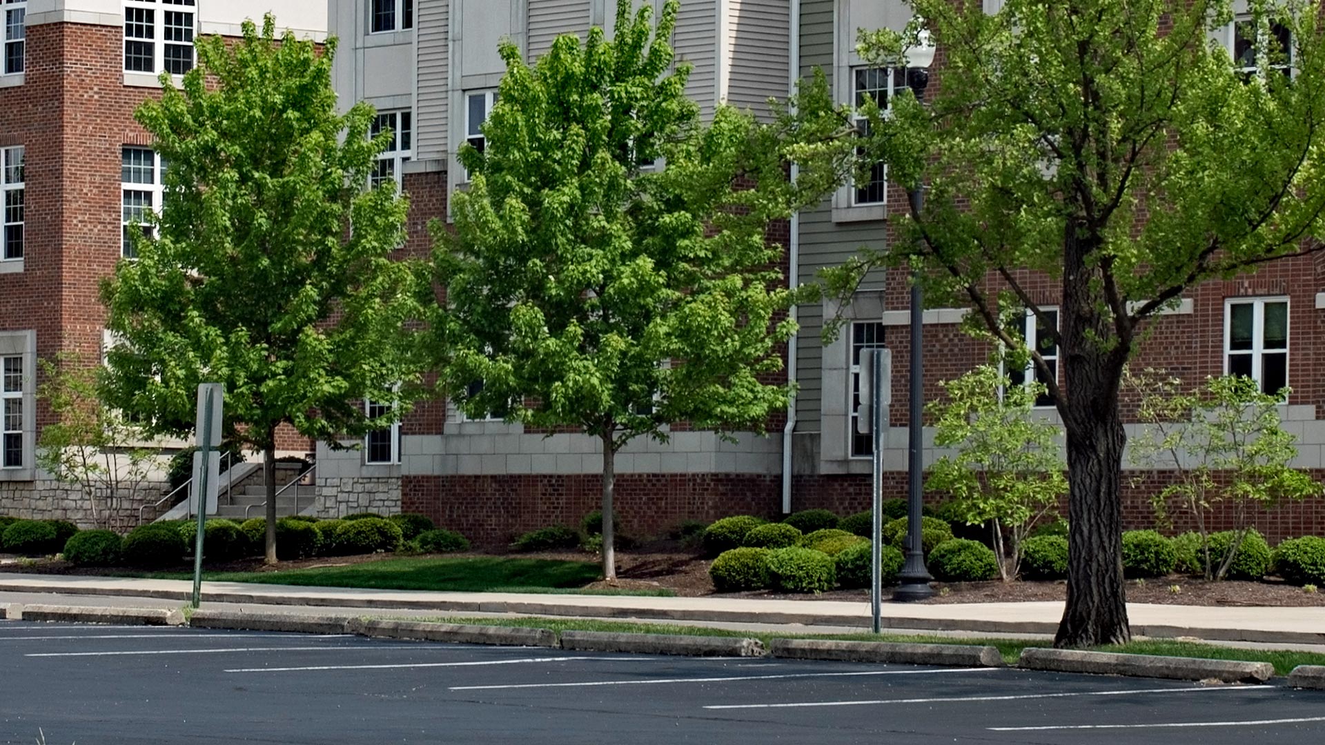 Large apartment complex with professionally trimmed shrubs, trees and grass that is regularly maintained by our team. 